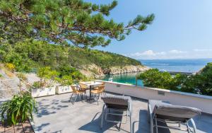 a patio with chairs and a table and the ocean at Seafront Apartment With Amazing Seaview in Vrbnik