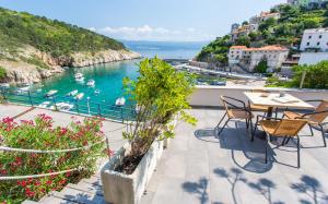a balcony with tables and chairs and a view of the water at Seafront Apartment With Amazing Seaview in Vrbnik