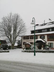 ein Straßenlicht vor einem Gebäude im Schnee in der Unterkunft Höhengasthof Rössle in Schluchsee