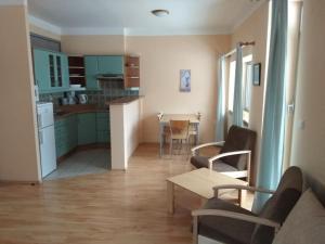 a kitchen and living room with a table and chairs at Apartmány Areál Ados in Harrachov