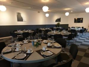 a conference room with tables and chairs and lights at Kanns Hotel in Åkirkeby