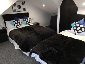 a bedroom with two beds and two nightstands at Havering Guest House in Romford