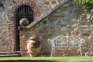 a white bench sitting in front of a building with a window at Magnolia House in Cetona