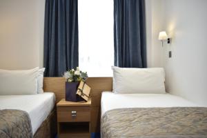 um quarto de hotel com duas camas e uma janela em Central Park Hotel em Londres