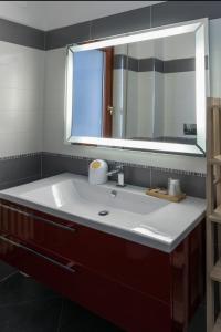 a bathroom with a white sink and a mirror at XX Settembre Matera - Apartment in Matera