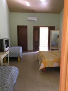 a room with two beds and a tv and a mirror at Espaço Smidt in Santa Branca