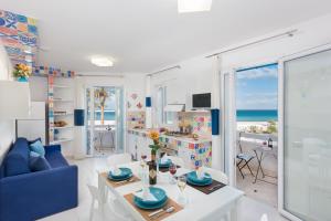 a living room with a table and a blue couch at Residence Le Palme in San Vito lo Capo