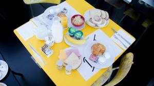 a yellow table with breakfast foods and drinks on it at Blanc Kara- Adults Only in Miami Beach