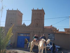 un groupe de personnes à cheval devant un bâtiment dans l'établissement Gite Kasbah La Palmeraie, à Skoura