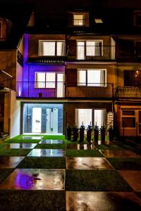 un edificio con luces púrpuras en el lateral. en Adonis Apartments, en Świnoujście