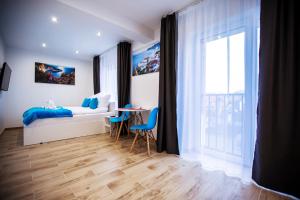 1 dormitorio con cama, mesa y ventana en Adonis Apartments, en Świnoujście