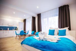 a bedroom with a bed with two swans on it at Adonis Apartments in Świnoujście