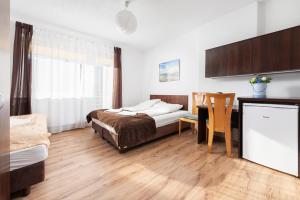 a bedroom with a bed and a desk and a table at FajnePokoje - ANTEK in Władysławowo