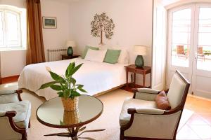 a bedroom with a bed and a table and chairs at Eugaria Country House by Lost Lisbon in Sintra