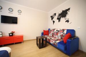 イジェフスクにあるFive Stars Avrora Parkのリビングルーム(青いソファ付)、壁に世界地図