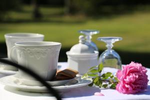 a table with a cup and a plate and a bottle at Magnolia House in Cetona