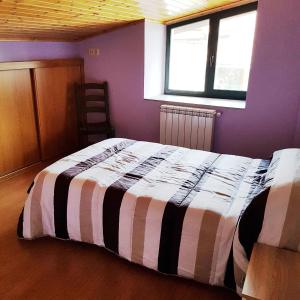 a bedroom with a bed with a striped blanket at Moreiriña- Bentraces in Bentraces +23 photos