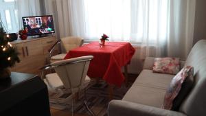 sala de estar con mesa y mantel rojo en Ferienhaus II Heyder en Elbingerode