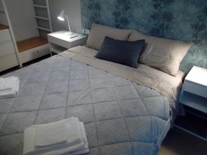 een slaapkamer met een groot bed met een blauwe muur bij Bologna House Due Torri Apartment in Bologna