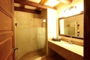 een badkamer met een wastafel en een douche met een spiegel bij Hotel Quinta Mision in Creel