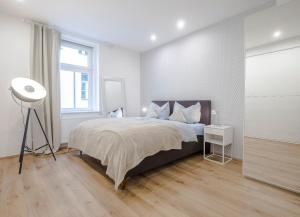 a bedroom with a bed, desk, and chair at INNSBRUCK CITY APARTMENTS ***** in Innsbruck