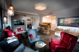 a living room with couches and chairs and a television at Wallner - Hotel & Wirt in Arnoldstein