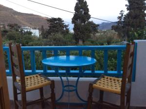 a blue table and two chairs on a balcony at Anixi in Astypalaia