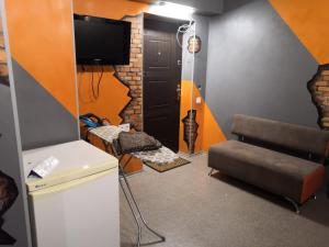 a room with a tv and a couch and a chair at Graffiti Mega City in Kyiv
