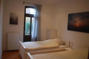 a bedroom with a white bed and a window at Ferienwohnung im Grünen - Hof Blohme in Langwedel