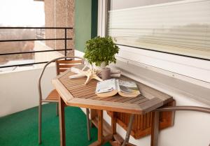 una mesa con una maceta junto a una ventana en Ferienwohnungen Tobian, en Glücksburg