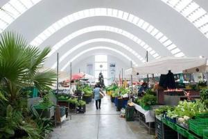 a woman walking through an indoor market with plants at Je T'aime Matosinhos Beach in Matosinhos