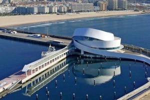 a large building in the water next to a beach at Je T'aime Matosinhos Beach in Matosinhos