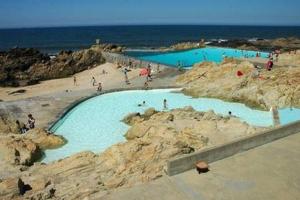 a group of people on a beach with blue water at Je T'aime Matosinhos Beach in Matosinhos