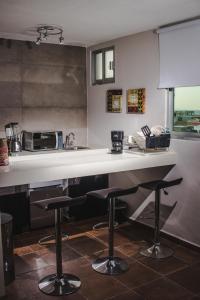 une cuisine avec un comptoir et deux tabourets de bar dans l'établissement HOTEL CAREYES, à Coatzacoalcos