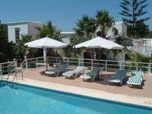 una piscina con tumbonas y sombrillas junto a una piscina en Can Joan Yern en Sant Joan de Labritja