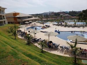 a pool with tables and umbrellas in a resort at ILHAS DO LAGO ECO RESORT in Caldas Novas