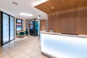 un hall de bureau avec un comptoir de réception et une table dans l'établissement Hotel Residence Europe & Spa, à Clichy