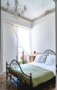 シラクーサにあるAppartamento Calarossaのベッドルーム1室(シャンデリア、窓付)