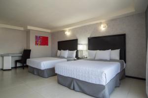 奧里薩巴的住宿－哈酒店，酒店客房配有两张床和一张书桌