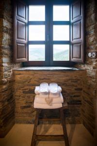 dos toallas en un taburete frente a una ventana en Aldea Rural y Gastro Restaurante Casona de Labrada, en Labrada