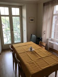 a dining room with a table with chairs and windows at Bad Ragaz Appartement in Bad Ragaz
