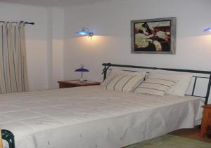 ein Schlafzimmer mit einem großen weißen Bett in einem Zimmer in der Unterkunft Vivenda V3 Praia Verde in Castro Marim