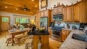 cocina con armarios de madera, mesa y comedor en Red Cedar Cabin, en Franklin