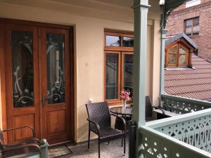 a balcony with a wooden door and chairs and a table at ApartHotel Heart of Tbilisi in Tbilisi City