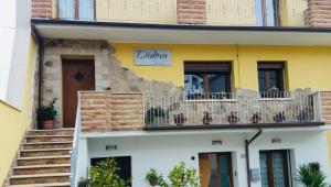 un edificio giallo con balcone fiorito di B&B Didova a Gavoi