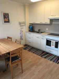 een keuken met een houten tafel en een keuken met witte kasten bij Bad Ragaz Appartement in Bad Ragaz