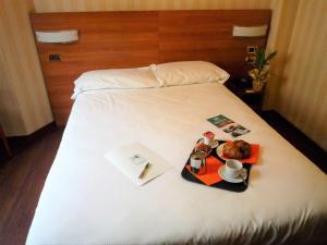 ein Hotelbett mit einem Tablett mit Essen darauf in der Unterkunft Hotel 2C in Legnano