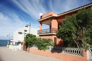 a building on the side of a street next to the ocean at Appartamenti Mare Blu in Isola Rossa