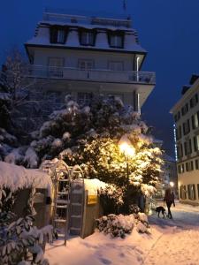 a building in the snow with a person and a dog at Bad Ragaz Appartement in Bad Ragaz