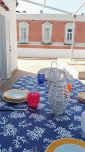 伊斯基亞的住宿－Terrazzo 73，一张桌子,上面有盘子和碗,放在蓝色的桌布上